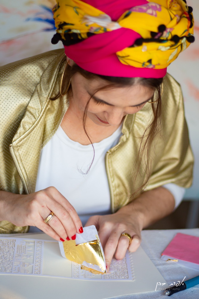 An artist meticulously working on a Ketubah design